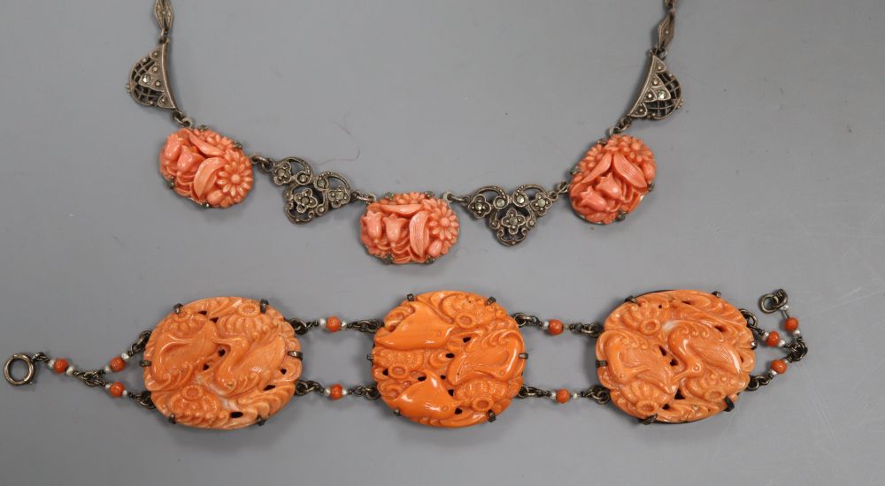 An early 20th century metal and carved coral panel set bracelet and a coral necklace